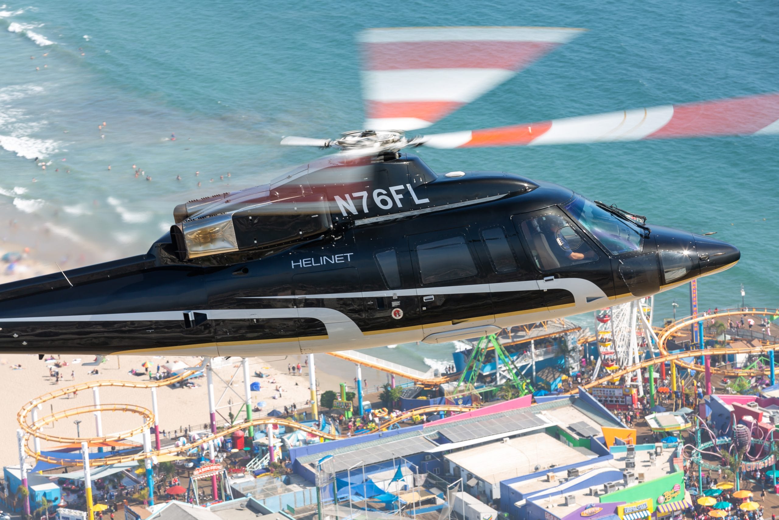 Helinet helicopter flying over the beach